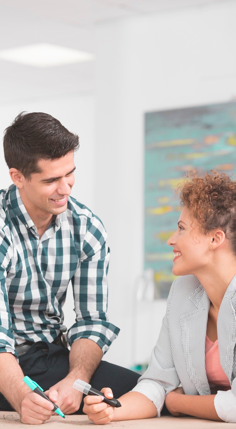 Handsome businessman flirting with his female workmate in office